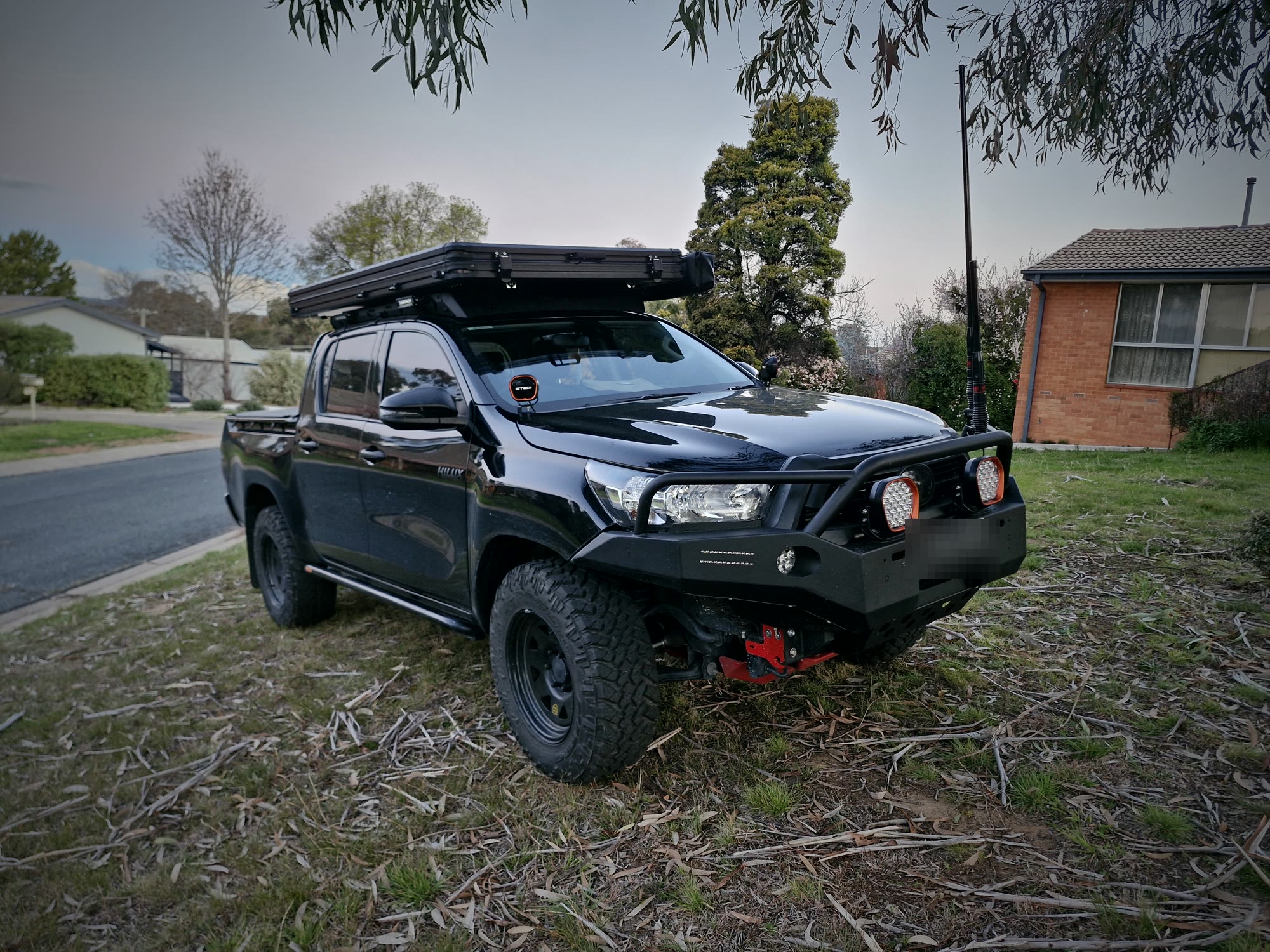 Black Hilux with LED driving lights on the bullbar and a rooftop tent